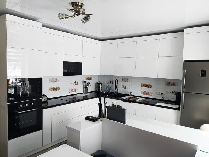Designer kitchen with white cabinetry and a dark stone worktop